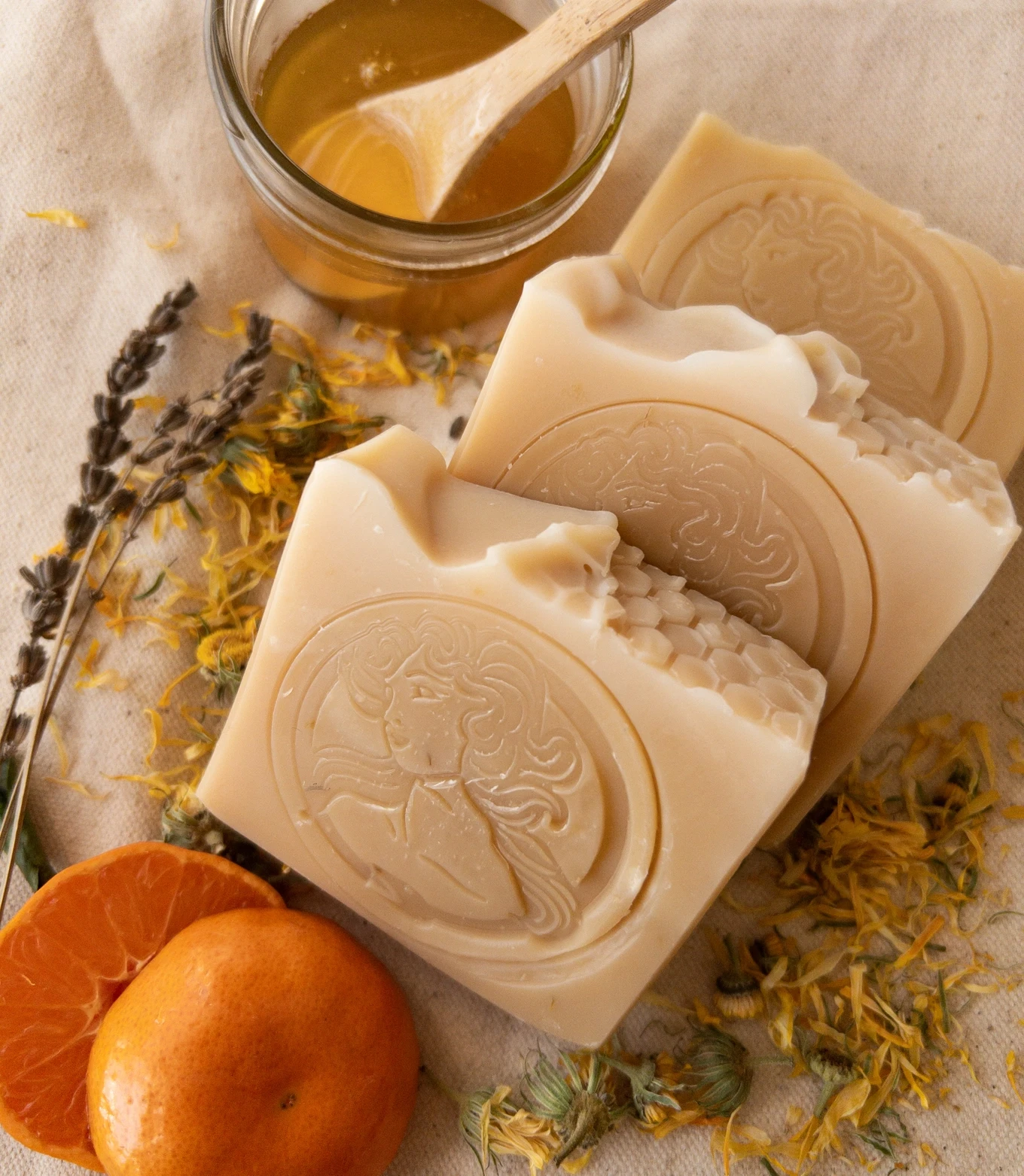 Handmade cameo-stamped soap bars with honey, dried calendula, lavender, and mandarin oranges