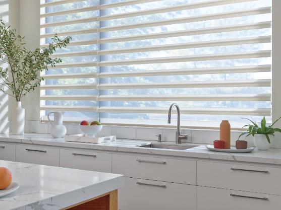 Pirouette sheer shades filtering light over a kitchen sink window