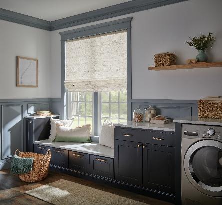 Classic woven roman shade over a window seat in a laundry room